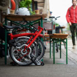 Brompton bike folded next to table